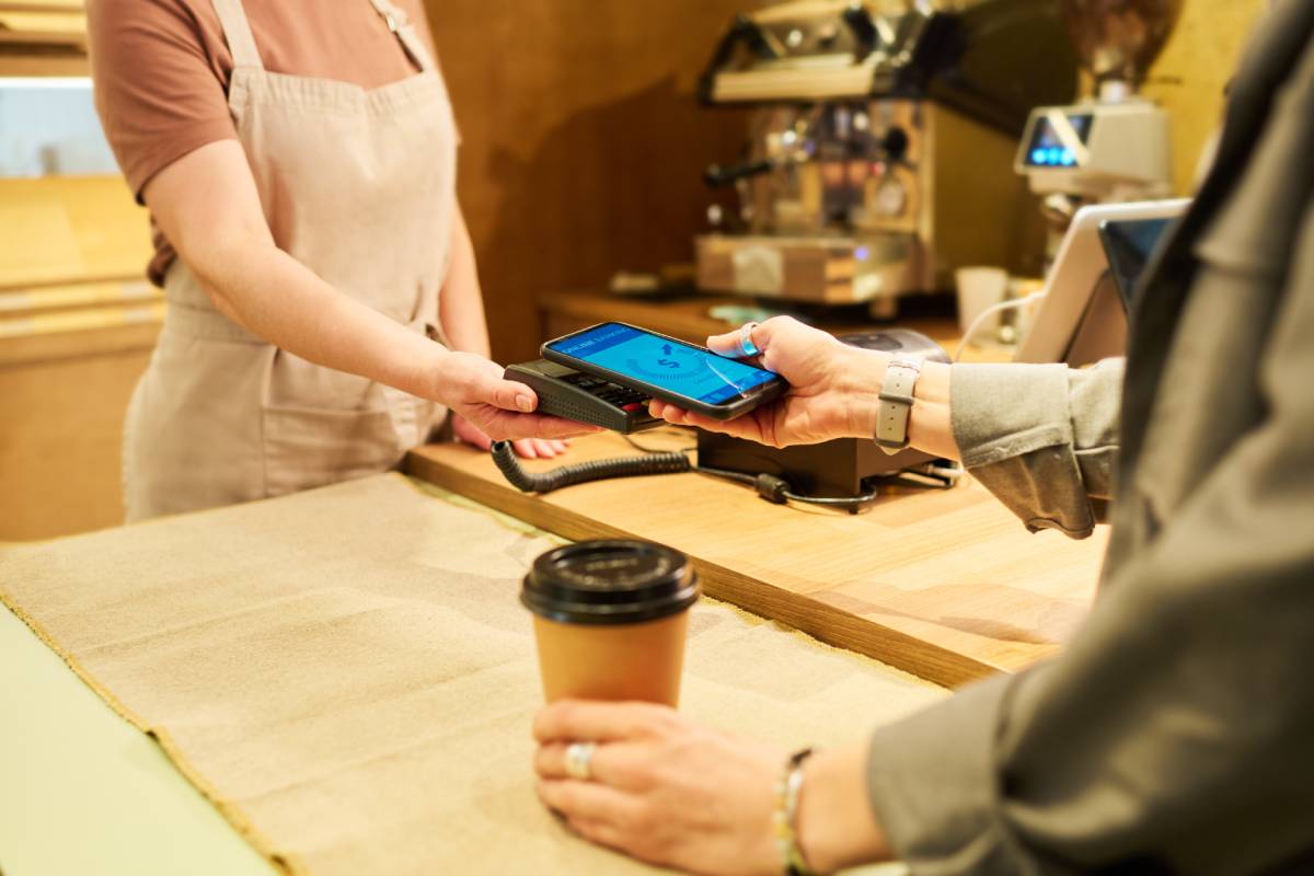 A person paying for their coffee with their smartphone.