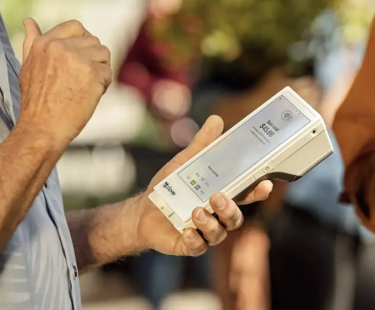 A man holding a Clover Flex portable terminal.