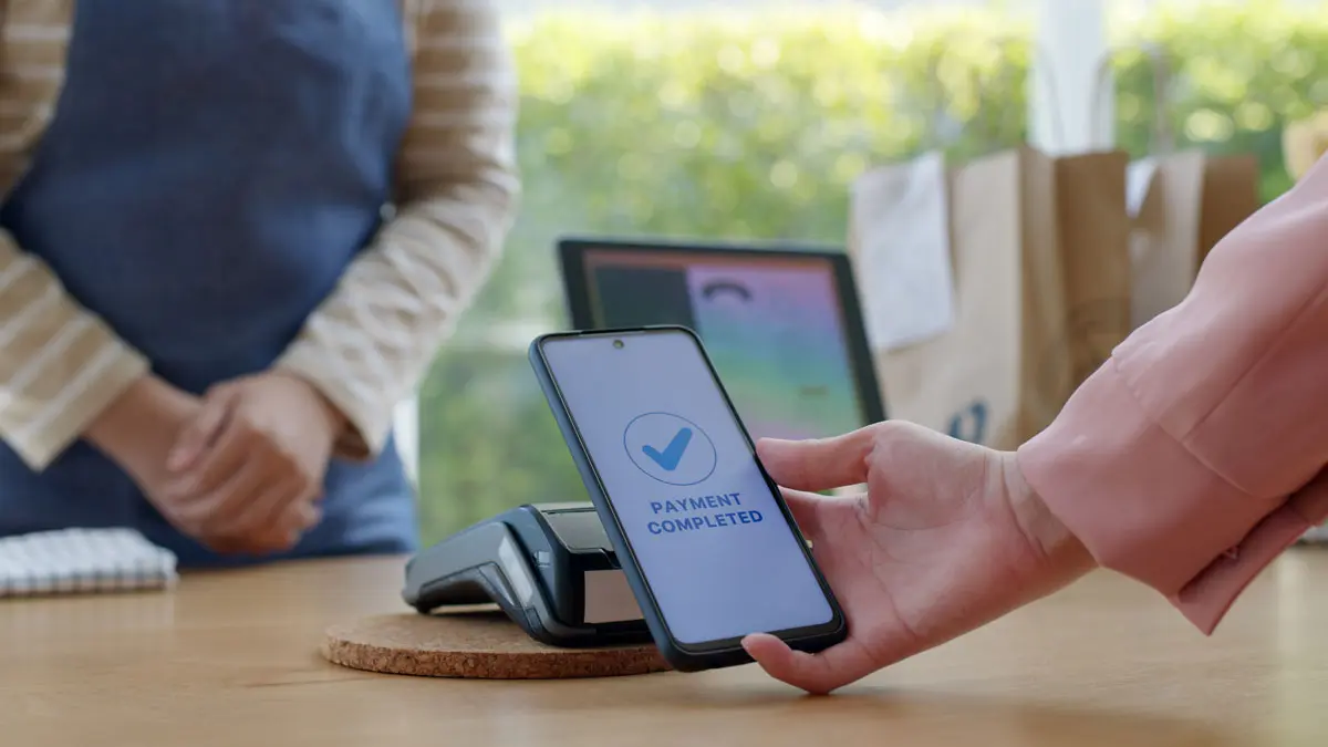 A person paying with their phone at a store