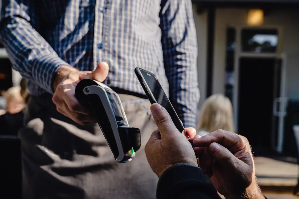 A person paying their bill on contactless payment system at a restaurant
