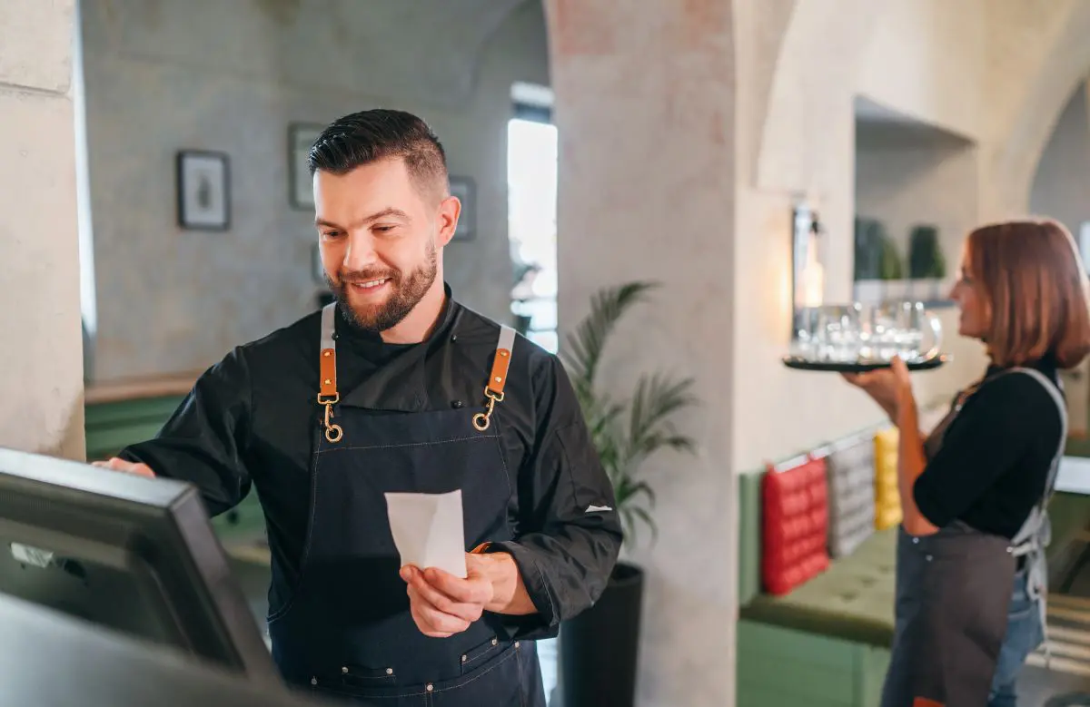A restaurant employee using a POS system