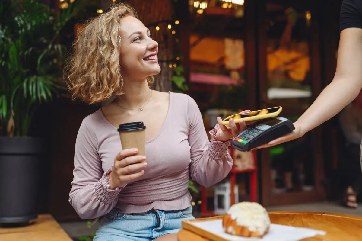 A woman paying for coffee with her phone